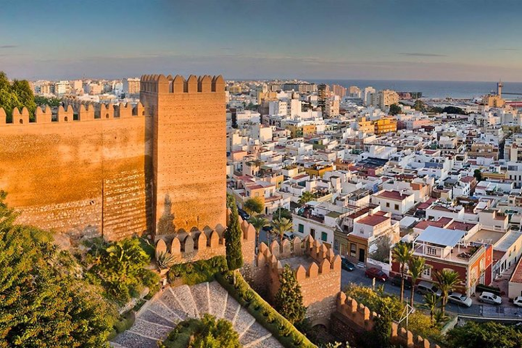 View of the Alcazaba of Almeria, a historic fortress with tall brick walls overlooking the cityscape and coastline of Almeria, Spain..png