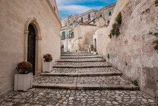 Photo of panoramic view of the ancient town of Matera (Sassi di Matera), European Capital of Culture 2019, in beautiful golden morning light with blue sky and clouds, Basilicata, southern Italy.