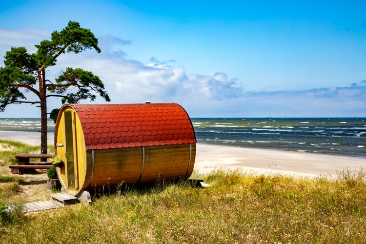 photo of view of Small wooden camping on the shores of the Baltic Sea in Cape Kolka, Kurzeme region, Latvia. Summer vacation beautiful peaceful scenery.