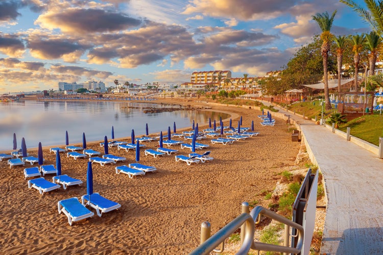 Photo of Kalamies beach in Protaras city. Beach with blue sunbeds and umbrellas.