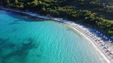 Photo of white boat in crystal clear blue sea water, Argostoli, Greece.