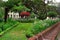 Municipal park in center of Madeira's capital is Funchal. Flowering plants and birds singing have tourists to sit on a stone bench for relaxing during the Flowers Festival in Madeira.