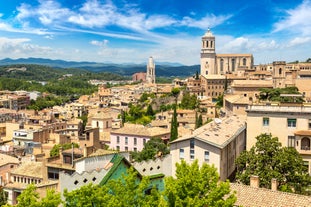 Photo of colorful yellow and orange houses and Eiffel Bridge, Old fish stalls, reflected in water river Onyar, in Girona, Catalonia, Spain.