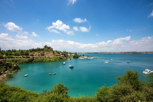 Touristic sightseeing ships in Golden Horn bay of Istanbul and mosque with Sultanahmet district against blue sky and clouds. Istanbul, Turkey during sunny summer day.