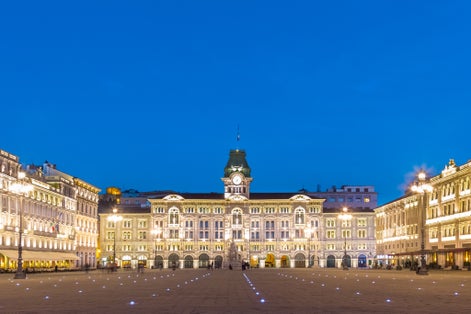 The City Hall, Palazzo del Municipio, is the dominating building on Trieste's main square Piazza dell Unita d Italia. Trieste, Italy, Europe. Illuminated city square shot at dusk.