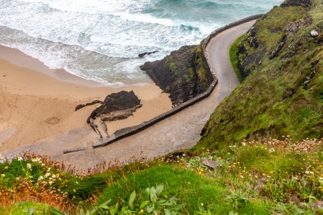 photo of Road to Coumeenoole beach with Cliffs and vegetation, Dingle, Kerry, Ireland .