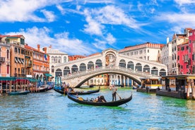 Famous buildings, gondolas and monuments by the Rialto Bridge of Venice on the Grand Canal, Italy.