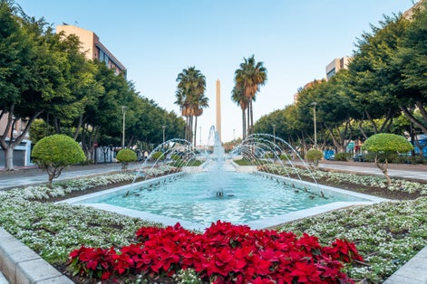 Photo of water fountain and flowers next to the palm trees in the Belen street of the Rambla de Almeria.