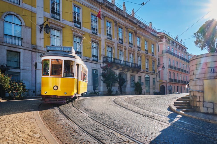 Photo of Famous vintage yellow tram 28 in the narrow streets of Alfama district in Lisbon, Portugal - symbol of Lisbon, famous popular travel destination and tourist attraction.