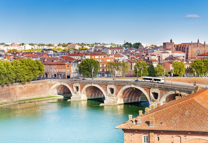 Photo of Toulouse and Pont Neuf bridge across Garonne river, France.