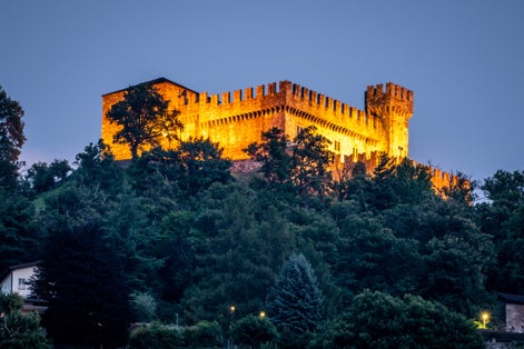 photo of Sasso Corbaro medieval castle illuminated at night in Bellinzona, Switzerland.