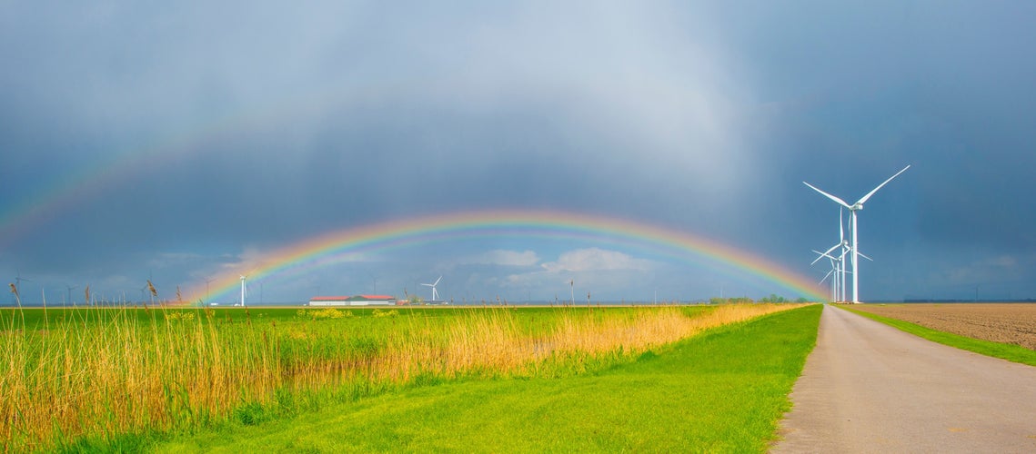 Dark sky and a rainbow over a rural landscape, Almere, Flevoland, The Netherlands.