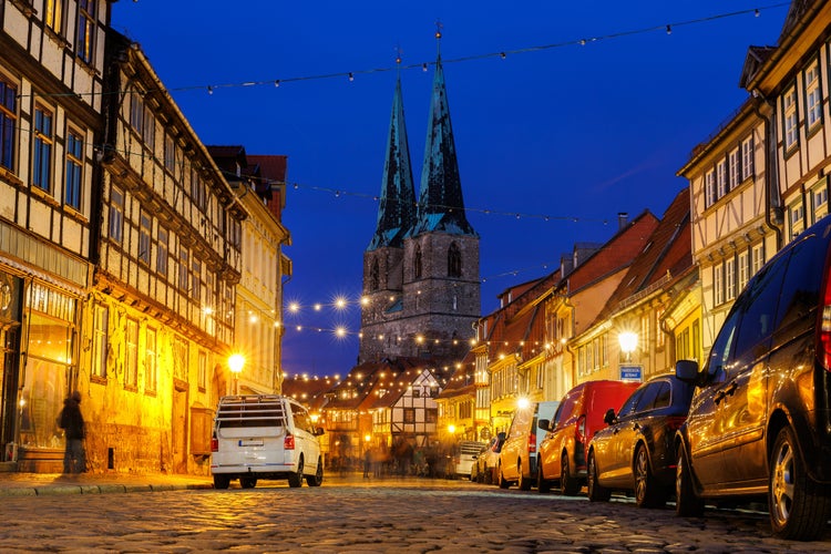 photo of view of Charming Quedlinburg town evening street view illuminated with Christmas lights old St. Nicholas Church St. Nicholas Kirche background historical half-timbered houses facade. Festive city German