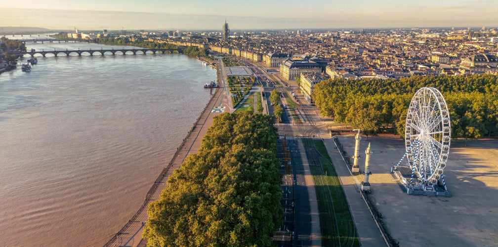 Aerial view of Place des Quinconces and the Garonne River in Bordeaux with Ferris wheel and tree-lined promenade..jpg