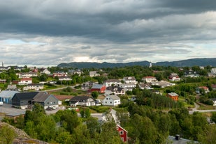 Photo of red houses facades reflecting on the bay of Alta, Norway.