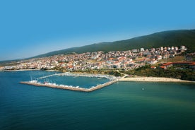 Photo of Saint Anastasia Island in Burgas bay, Black Sea, Bulgaria. Lighthouse tower and old wooden buildings on rocky coast.