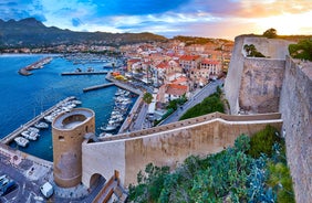 Photo of aerial view from the walls of the citadel of Calvi on the old town with historic buildings and bay with yachts and boats, Corsica, France.