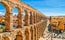 Photo of Ancient Roman aqueduct on Plaza del Azoguejo square and old building towns in Segovia, Spain.