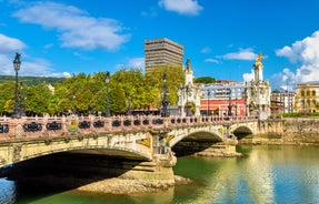 Photo of aerial view of Vizcaya bridge over the river and cityscape at Portugalete, Spain.