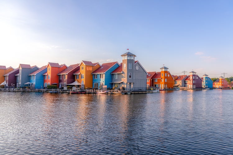 Colorful houses reflected in the frozen lake of Reitdiephaven in Groningen, Netherlands