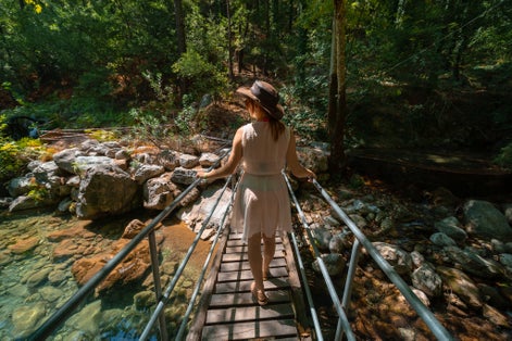 photo of traveler girl posing at the bridge at sapadere canyon in Summer sunny day in Antalya, Turkey.
