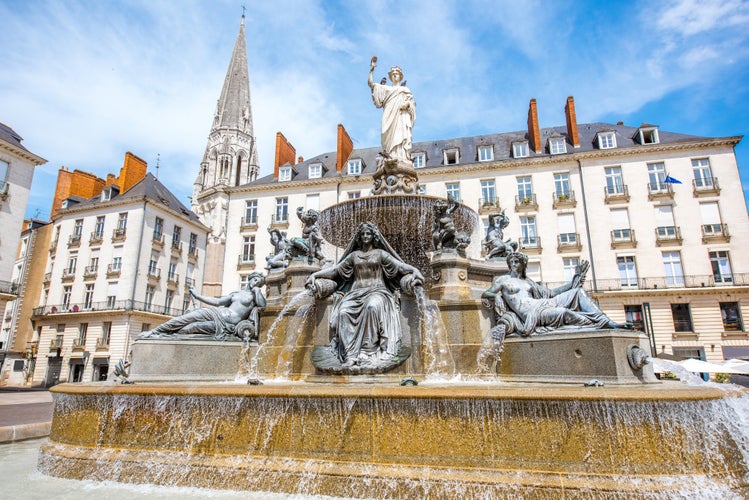 Photo of view on the Royal square with fountain and church tower in Nantes city in France.