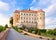 Photo of Mikulov castle or Mikulov Chateau on top of rock. View from garden of castle with beautiful staircase and bright blue sky with clouds in background, Mikulov, Moravia, Czech Republic.