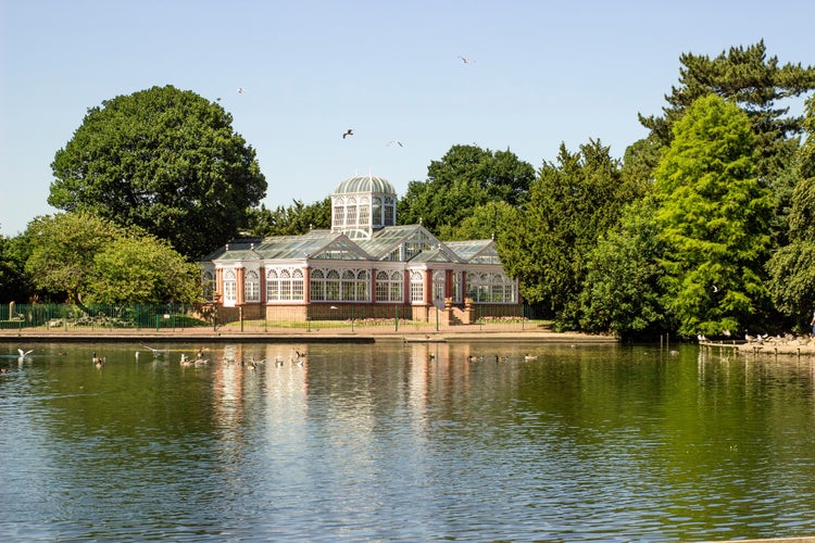 Photo of West Park in Wolverhampton, England. Beautiful view of lake, trees and Conservatory.