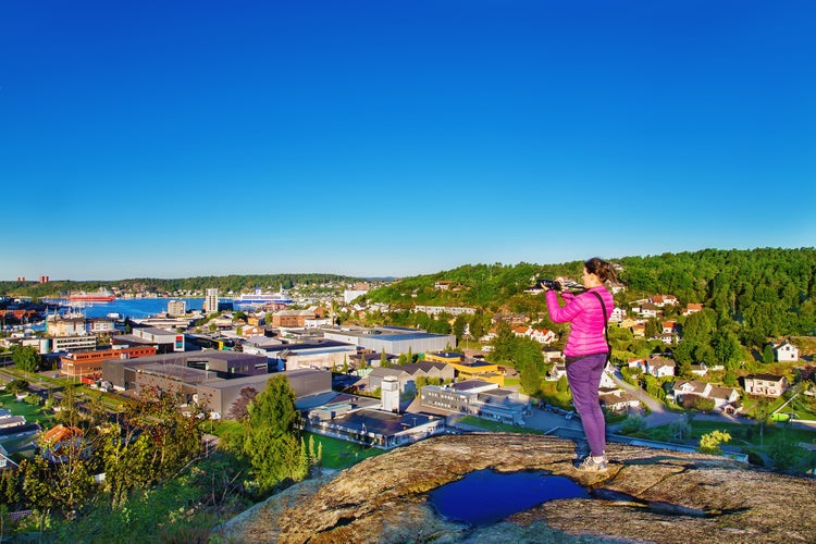 Woman with a photocamera early in the morning on a mount in Sandefjord. Norway