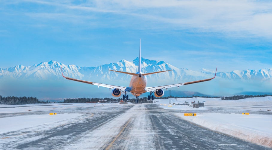 Photo of White passenger airplane landing on snowy airport - Oslo, Norway.