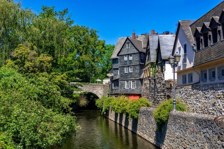 Row of houses of winding, old, partly with slate tiles covered residential houses with a brook in the old town of Wetzlar, Hesse, Germany