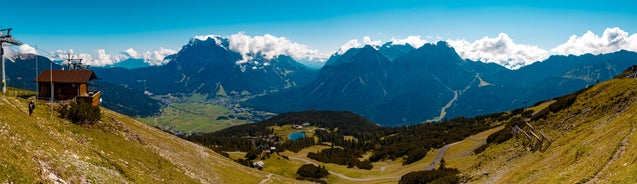 Photo of aerial view of the city of Lermoos, Austria with the Alps mountains in the background on a sunny summer day.