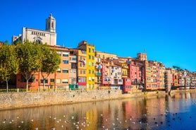 Photo of colorful yellow and orange houses and Eiffel Bridge, Old fish stalls, reflected in water river Onyar, in Girona, Catalonia, Spain.