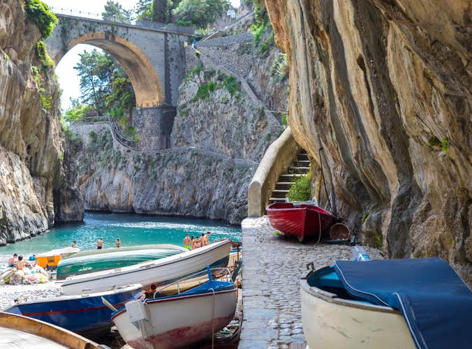 Fiordo di Furore beach. Furore Fjord Amalfi Coast Positano Naples Italy. - Fishermen colored boats on the beach, under the bridge of the fjord. The turquoise water of the beach.