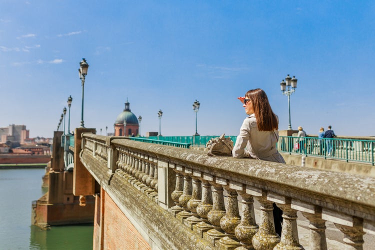 Photo of tourist woman in French ancient town Toulouse and Garonne river.