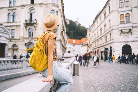 Photo of tourist on Triple Bridge in heart of Ljubljana old town, Slovenia.