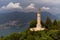 Aerial view of the Faro Voltiano (Volta Lighthouse) in Brunate, with the skyline of Lake Como, green forest and trees near Milan, Italy