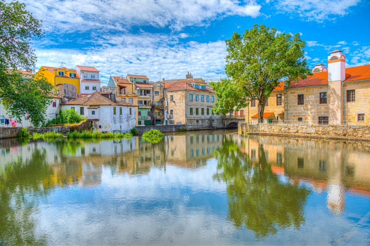 Photo of old buildings in Viseu reflected on a local creek, Portugal.