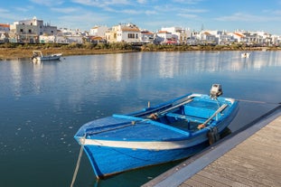 Photo of aerial cityscape of beautiful Tavira with roman bridge over Gilao river in the evening, Algarve, Portugal.