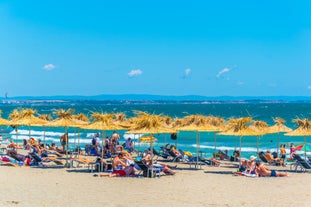 Photo of Saint Anastasia Island in Burgas bay, Black Sea, Bulgaria. Lighthouse tower and old wooden buildings on rocky coast.