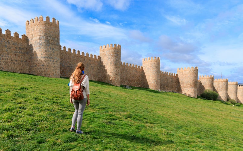 photo of view of Woman tourist enjoying view of Avila surrounding wall in Spain- Castile and Leon.