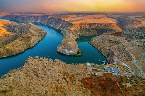 photo of aerial view of panoramic view of Rumkale from the magnificent sunset. The junction of the Euphrates River and Merzimen Stream in Kasaba, Turkey.