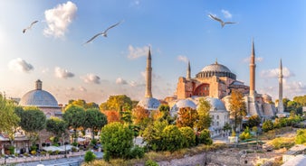 Touristic sightseeing ships in Golden Horn bay of Istanbul and mosque with Sultanahmet district against blue sky and clouds. Istanbul, Turkey during sunny summer day.