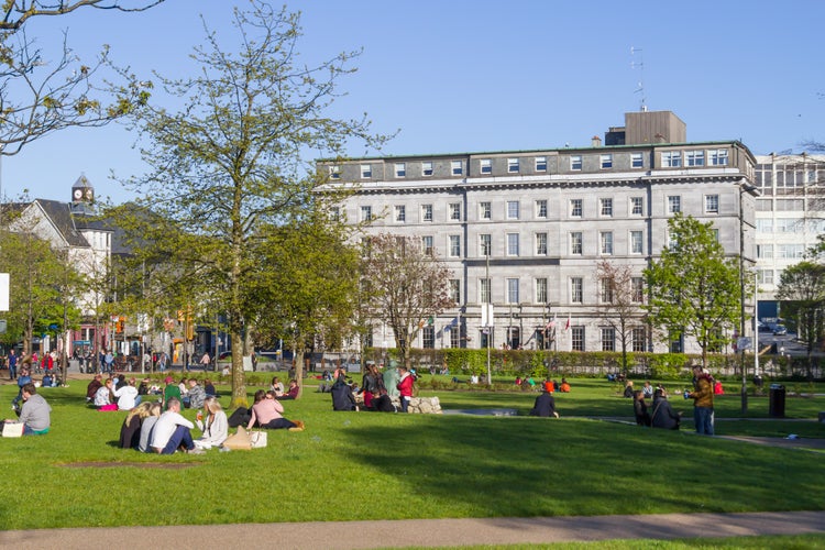 People talking and resting in Eyre Square Park, Galway, Ireland