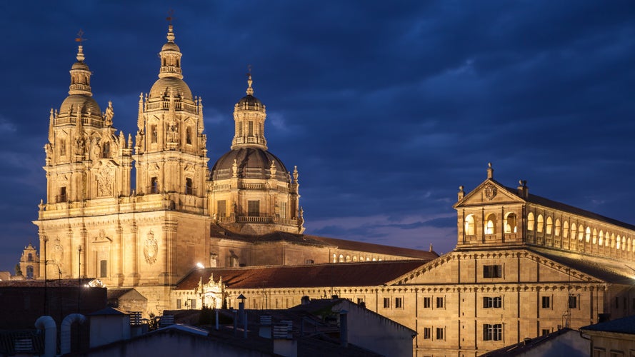 photo of view of Salamanca at night, Spain. La Clerecia Church and Pontifical University. Panoramic view, cityscape