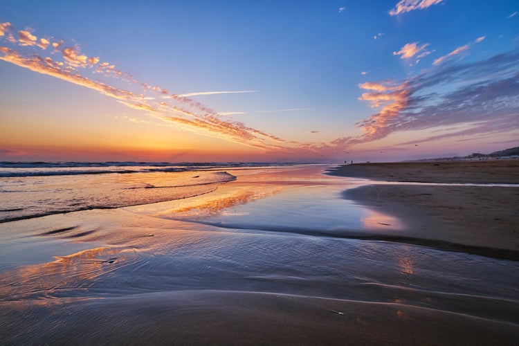 Photo of Atlantic ocean after sunset with surging waves at Fonte da Telha beach, Costa da Caparica, Portugal.