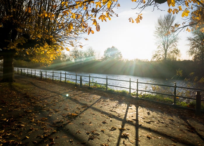 A beautiful sunset casts shadows on the path alongside the river Severn on a warm, autumn evening. Worcester, uk