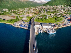 Photo of houses, bridge and panorama of Norwegian city Tromso beyond the Arctic circle from mountain in Norwegian fjords.