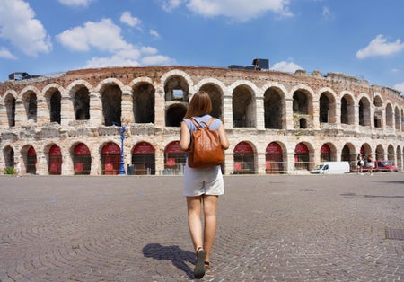photo of tourism in verona. Back view of tourist woman walks towards verona arena, Italy.