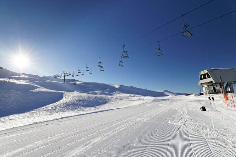 photo of Mountain Landscape of a sunny day on snow sky lopes on Italian Dolomiti, San Martino di Castrozza, Tognola Top with sun, the ski lift.